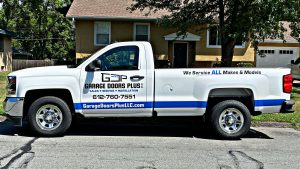 Garage Doors Plus work truck with logo parked in front of home